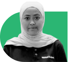 Portrait of a woman wearing a white hijab and black shirt, facing the camera against a green background.