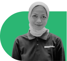 Portrait of a smiling woman wearing a hijab and a dark polo shirt with a small logo, in front of a green abstract background.